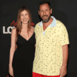 Adam Sandler y su esposa Jackie Sandler posan sonrientes juntos en una alfombra roja durante un estreno en Hollywood