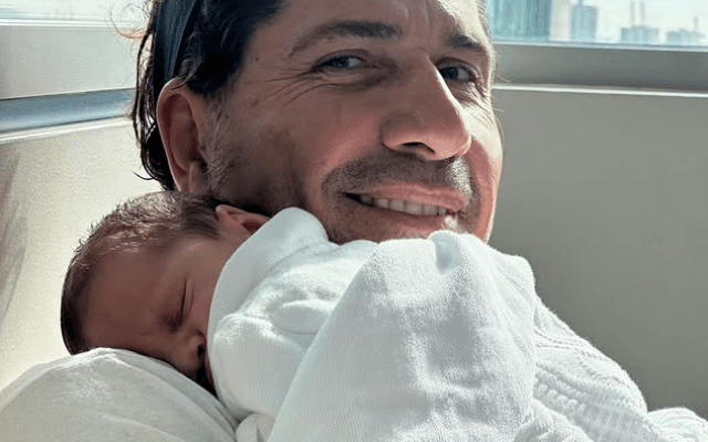 Gregorio Pernía sostiene en brazos a su hijo, en una imagen tierna que refleja cercanía y emoción familiar.